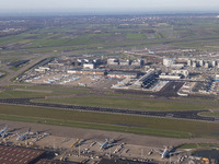 Aerial panoramic view of Amsterdam Airport Schiphol AMS EHAM from a departing airplane window. Aircraft, airport terminal, cargo terminal, r...