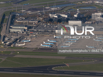 Aerial panoramic view of Amsterdam Airport Schiphol AMS EHAM from a departing airplane window. Aircraft, airport terminal, cargo terminal, r...