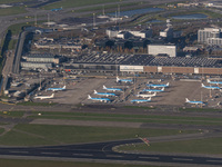 Aerial panoramic view of Amsterdam Airport Schiphol AMS EHAM from a departing airplane window. Aircraft, airport terminal, cargo terminal, r...