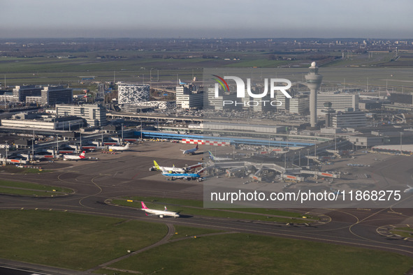 Aerial panoramic view of Amsterdam Airport Schiphol AMS EHAM from a departing airplane window. Aircraft, airport terminal, cargo terminal, r...