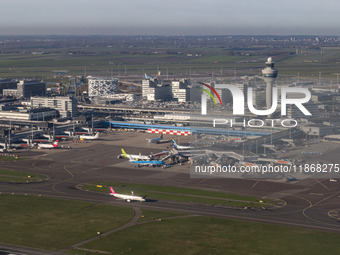 Aerial panoramic view of Amsterdam Airport Schiphol AMS EHAM from a departing airplane window. Aircraft, airport terminal, cargo terminal, r...