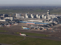 Aerial panoramic view of Amsterdam Airport Schiphol AMS EHAM from a departing airplane window. Aircraft, airport terminal, cargo terminal, r...