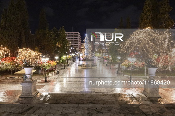 Festive night view of the iconic Syntagma Square adorned with dazzling Christmas decorations, featuring a towering Christmas tree illuminate...