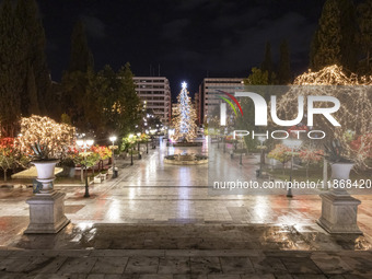 Festive night view of the iconic Syntagma Square adorned with dazzling Christmas decorations, featuring a towering Christmas tree illuminate...