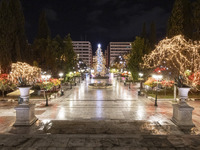 Festive night view of the iconic Syntagma Square adorned with dazzling Christmas decorations, featuring a towering Christmas tree illuminate...