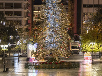 Festive night view of the iconic Syntagma Square adorned with dazzling Christmas decorations, featuring a towering Christmas tree illuminate...