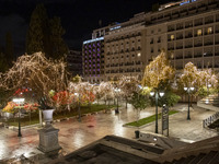 Festive night view of the iconic Syntagma Square adorned with dazzling Christmas decorations, featuring a towering Christmas tree illuminate...