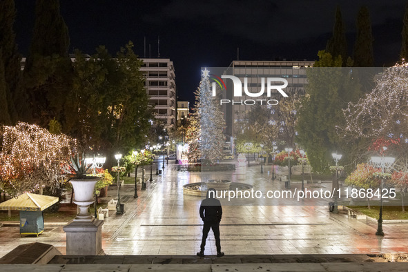 Festive night view of the iconic Syntagma Square adorned with dazzling Christmas decorations, featuring a towering Christmas tree illuminate...