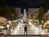 Festive night view of the iconic Syntagma Square adorned with dazzling Christmas decorations, featuring a towering Christmas tree illuminate...