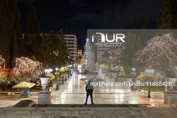 Festive night view of the iconic Syntagma Square adorned with dazzling Christmas decorations, featuring a towering Christmas tree illuminate...