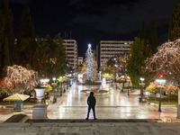 Festive night view of the iconic Syntagma Square adorned with dazzling Christmas decorations, featuring a towering Christmas tree illuminate...