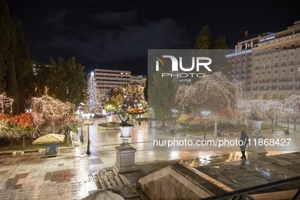 Festive night view of the iconic Syntagma Square adorned with dazzling Christmas decorations, featuring a towering Christmas tree illuminate...