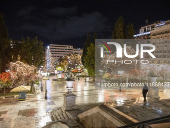 Festive night view of the iconic Syntagma Square adorned with dazzling Christmas decorations, featuring a towering Christmas tree illuminate...