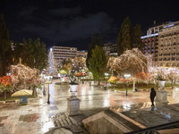 Festive night view of the iconic Syntagma Square adorned with dazzling Christmas decorations, featuring a towering Christmas tree illuminate...