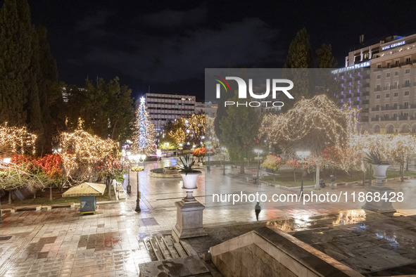 Festive night view of the iconic Syntagma Square adorned with dazzling Christmas decorations, featuring a towering Christmas tree illuminate...