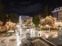 Festive night view of the iconic Syntagma Square adorned with dazzling Christmas decorations, featuring a towering Christmas tree illuminate...