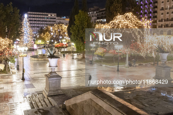 Festive night view of the iconic Syntagma Square adorned with dazzling Christmas decorations, featuring a towering Christmas tree illuminate...