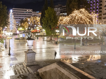 Festive night view of the iconic Syntagma Square adorned with dazzling Christmas decorations, featuring a towering Christmas tree illuminate...