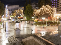 Festive night view of the iconic Syntagma Square adorned with dazzling Christmas decorations, featuring a towering Christmas tree illuminate...