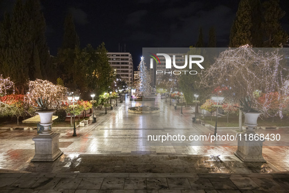 Festive night view of the iconic Syntagma Square adorned with dazzling Christmas decorations, featuring a towering Christmas tree illuminate...