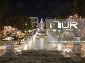 Festive night view of the iconic Syntagma Square adorned with dazzling Christmas decorations, featuring a towering Christmas tree illuminate...