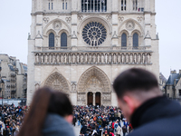 A couple and the crowd press on the forecourt of Notre-Dame Cathedral in Paris, on december 14, 2024. (