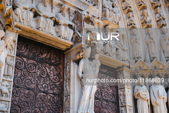 A door on the west facade of Notre Dame Cathedral features a statue of the Virgin Mary and baby Jesus. 