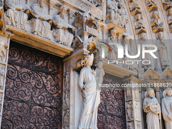 A door on the west facade of Notre Dame Cathedral features a statue of the Virgin Mary and baby Jesus. (