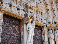 A door on the west facade of Notre Dame Cathedral features a statue of the Virgin Mary and baby Jesus. (