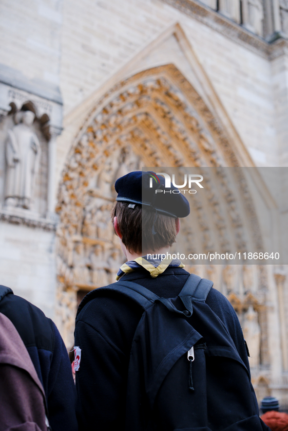 A scout admires Notre-Dame Cathedral on the forecourt, which is recently reopened to the public. 