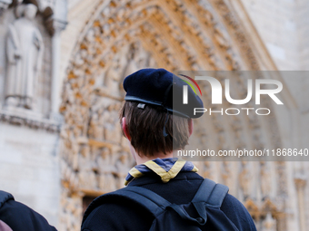 A scout admires Notre-Dame Cathedral on the forecourt, which is recently reopened to the public. (