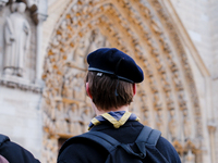 A scout admires Notre-Dame Cathedral on the forecourt, which is recently reopened to the public. (