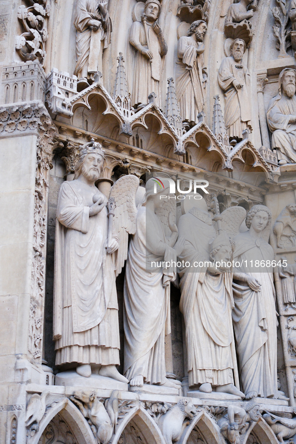 Statues of saints, kings, and angels are on Notre Dame Cathedral. 