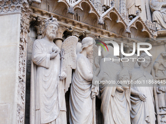 Statues of saints, kings, and angels are on Notre Dame Cathedral. (