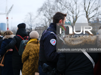 A police officer monitors the queue to visit Notre Dame Cathedral. (