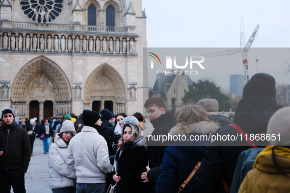 People stand in the queue to visit Notre Dame Cathedral. 