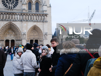 People stand in the queue to visit Notre Dame Cathedral. (