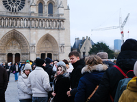 People stand in the queue to visit Notre Dame Cathedral. (