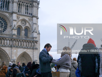 A couple stands on the forecourt of Notre-Dame Cathedral. (