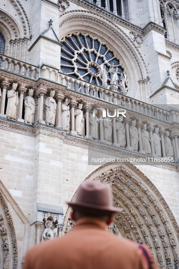 People stand in front of Notre Dame Cathedral in Paris, on december 14, 2024. 