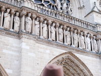 People stand in front of Notre Dame Cathedral in Paris, on december 14, 2024. (