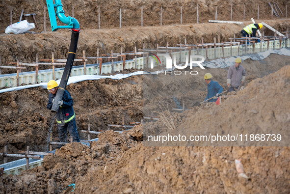 Workers work at the Qingjiangpu section of the second phase of the Huaihe River Waterway project in Huai 'an City, Jiangsu Province, on Dece...