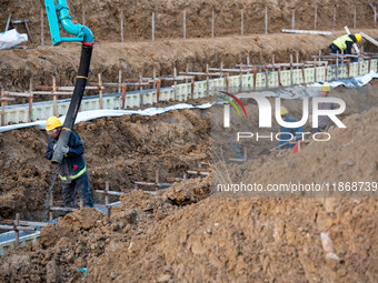 Workers work at the Qingjiangpu section of the second phase of the Huaihe River Waterway project in Huai 'an City, Jiangsu Province, on Dece...