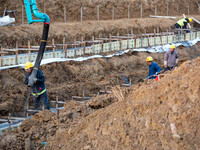 Workers work at the Qingjiangpu section of the second phase of the Huaihe River Waterway project in Huai 'an City, Jiangsu Province, on Dece...