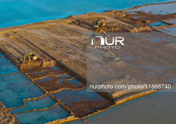 Workers work at the Qingjiangpu section of the second phase of the Huaihe River Waterway project in Huai 'an City, Jiangsu Province, on Dece...