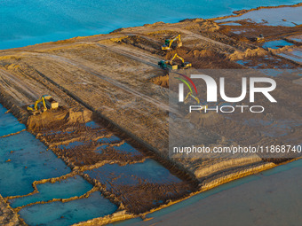 Workers work at the Qingjiangpu section of the second phase of the Huaihe River Waterway project in Huai 'an City, Jiangsu Province, on Dece...