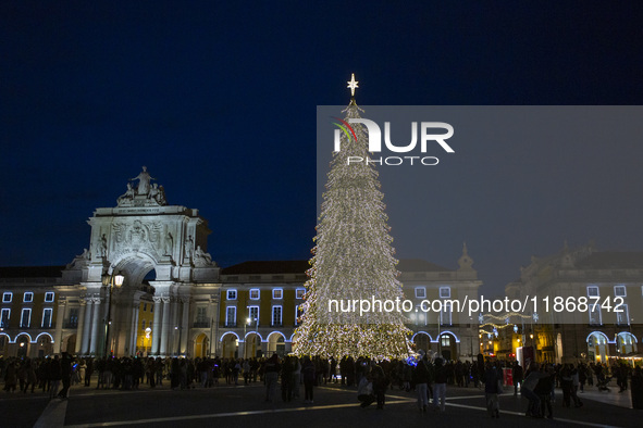 People gather around the Christmas lights at Praca do Comercio in Lisbon, Portugal, on December 14, 2024. The Christmas lights in Lisbon are...