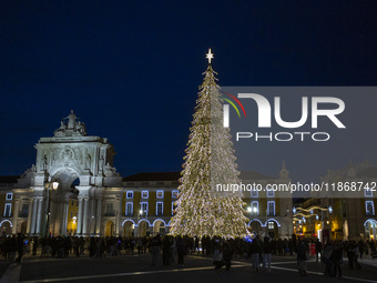 People gather around the Christmas lights at Praca do Comercio in Lisbon, Portugal, on December 14, 2024. The Christmas lights in Lisbon are...