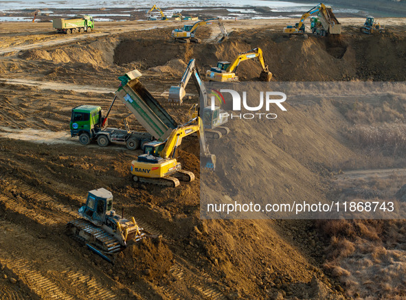 Workers work at the Qingjiangpu section of the second phase of the Huaihe River Waterway project in Huai 'an City, Jiangsu Province, on Dece...