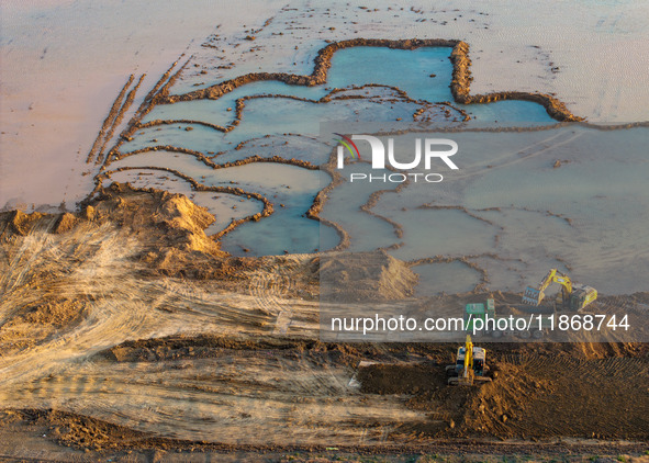 Workers work at the Qingjiangpu section of the second phase of the Huaihe River Waterway project in Huai 'an City, Jiangsu Province, on Dece...